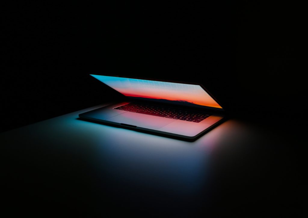 An ajar laptop in a dark room