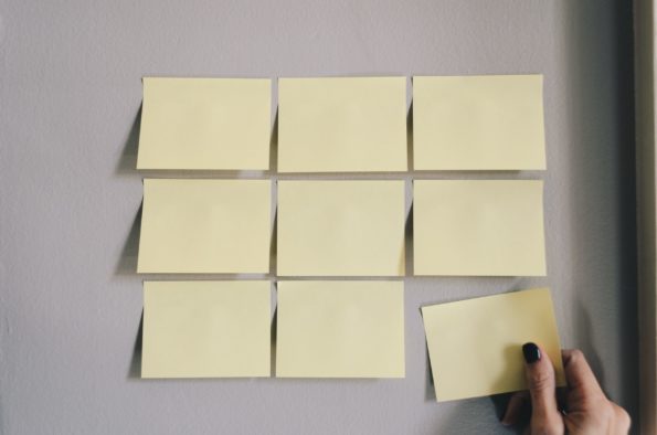 Blank yellow post-it notes stuck on a wall arranged in a grid formation