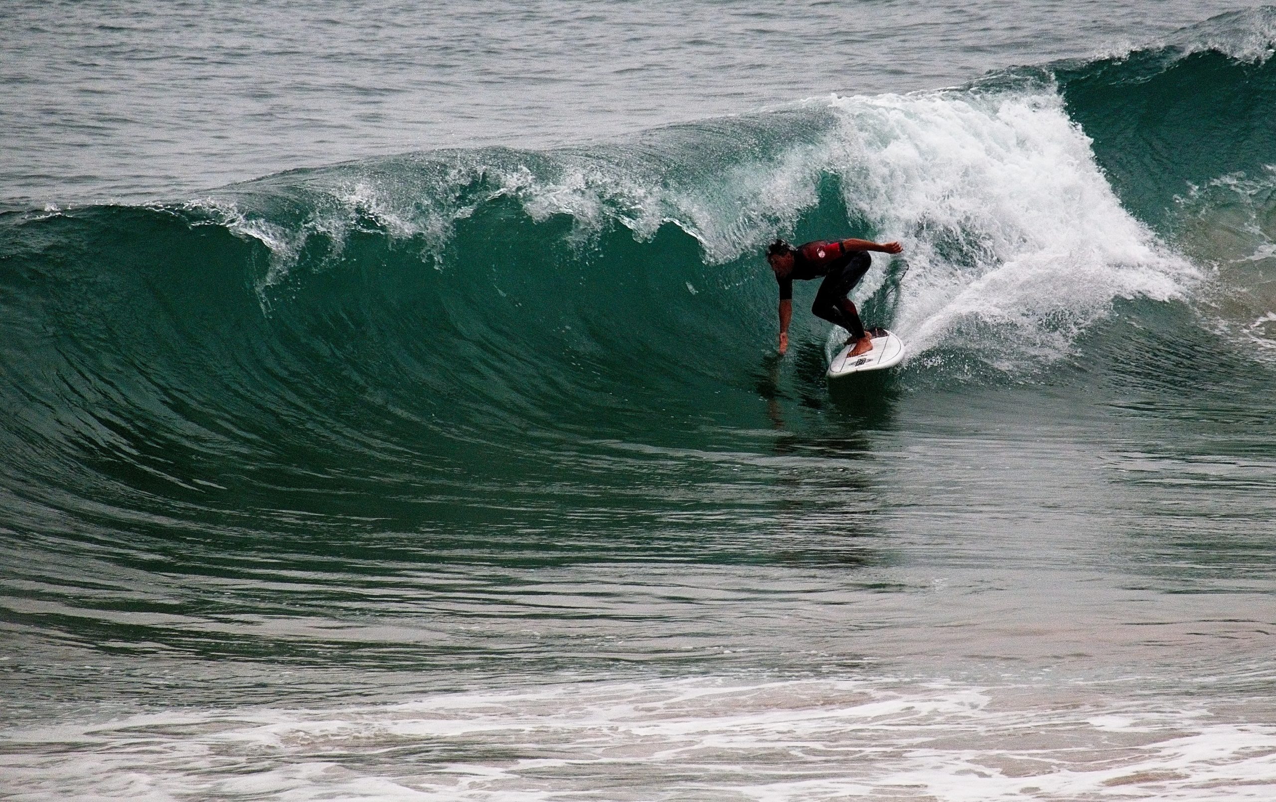 Surfer riding a small wave in ocean