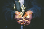 Hands holding a bright lightbulb